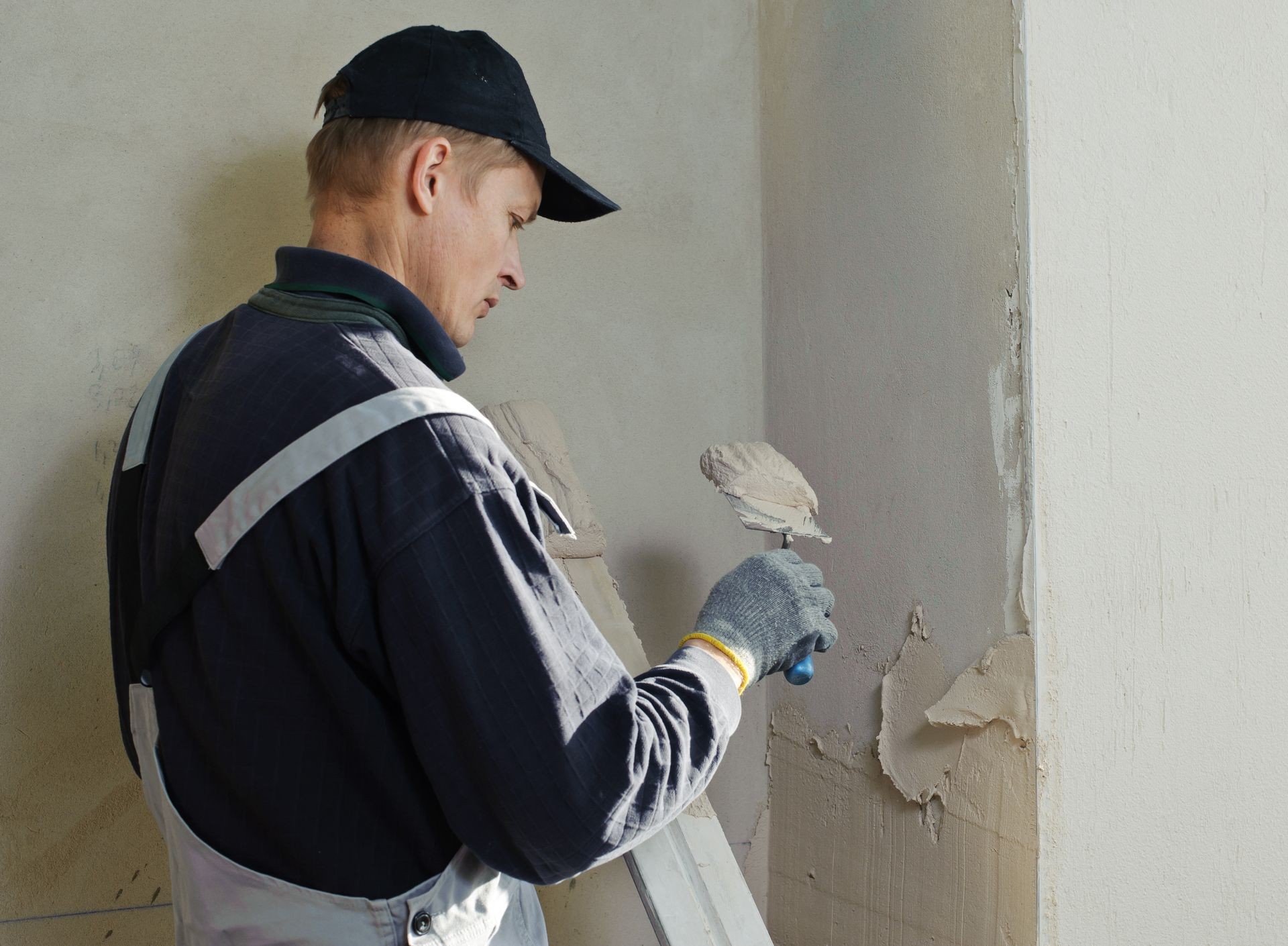 Man gets manually gypsum plaster on the wall Man gets manually gypsum plaster on the wall